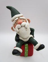 Christmas folk art Santa sitting on a present