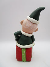 Christmas folk art Santa sitting on a present