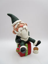 Christmas folk art Santa sitting on a present