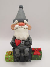 Christmas folk art Santa sitting on gifts holding red heart