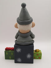 Christmas folk art Santa sitting on gifts holding red heart