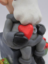 Christmas folk art Santa sitting on gifts holding red heart