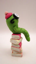 Valentine folk art little bookworm with glasses on stack of famous books