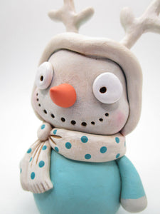 Christmas Snowman wearing a teal reindeer suit and antlers