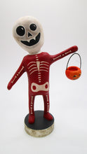 Halloween folk art spooky skeleton wearing a red bone costume with vintage style pumpkin - paper clay