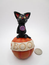 Halloween folk art black cat on pumpkin with BOO banner