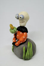 Halloween folk art Skelly Skeleton sitting on a rock