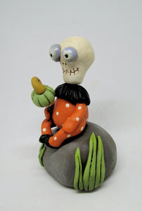 Halloween folk art Skelly Skeleton sitting on a rock