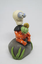 Halloween folk art Skelly Skeleton sitting on a rock