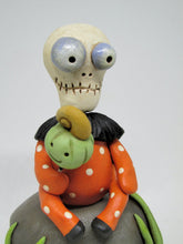 Halloween folk art Skelly Skeleton sitting on a rock
