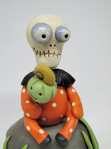 Halloween folk art Skelly Skeleton sitting on a rock